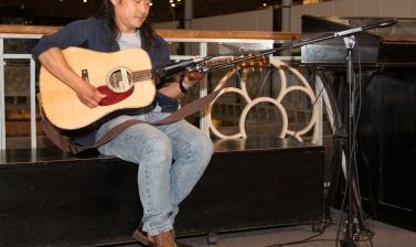 Gu Feng playing guitar at exhibition opening